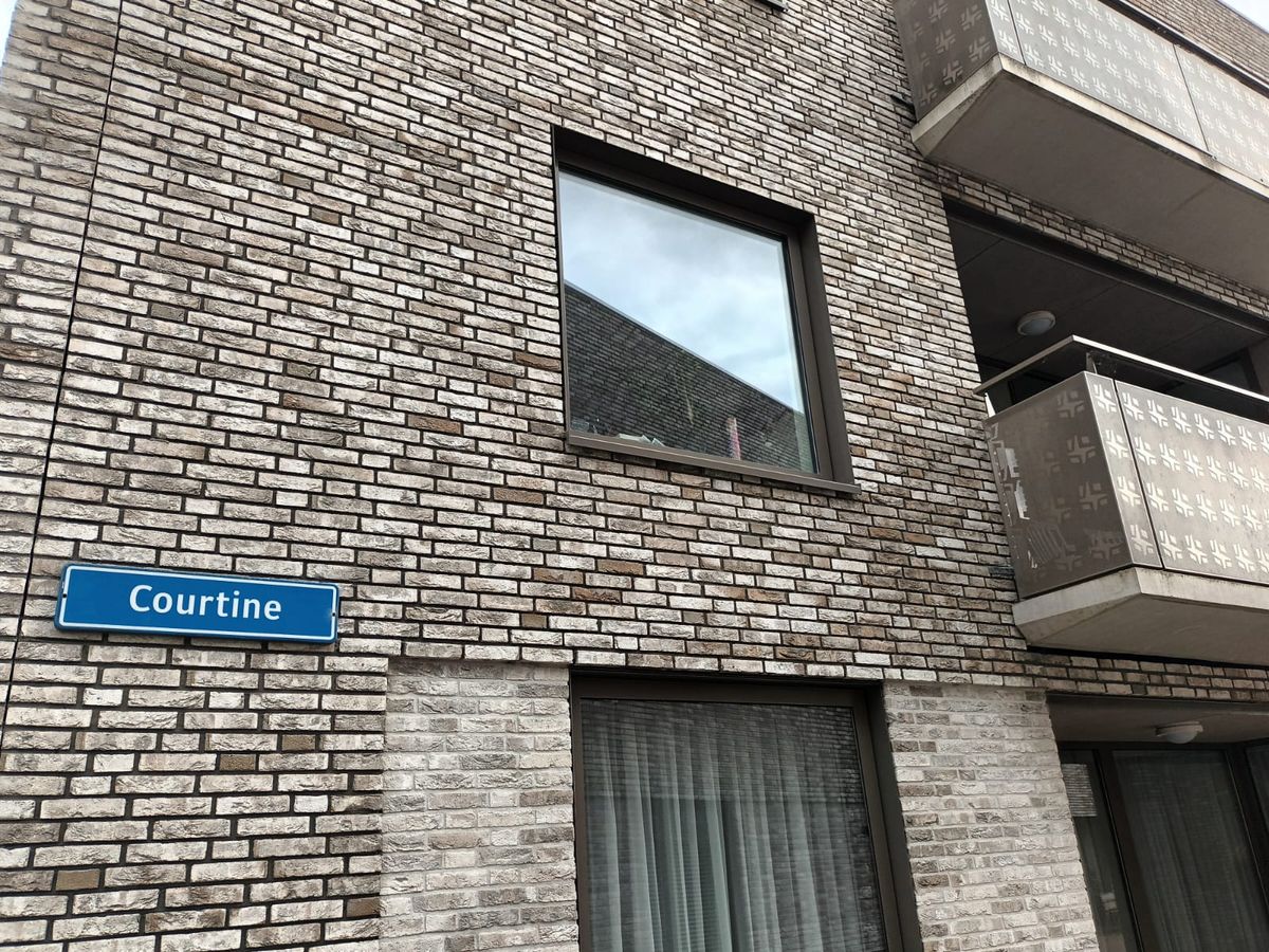Het straatnaambord 'Courtine' op de gevel van het woongebouw